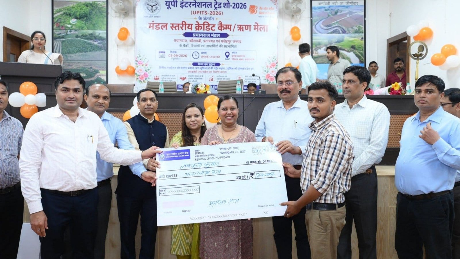 प्रयागराज मंडल के क्रेडिट कैंप में लाभार्थियों को लोन का चेक देते अधिकारी